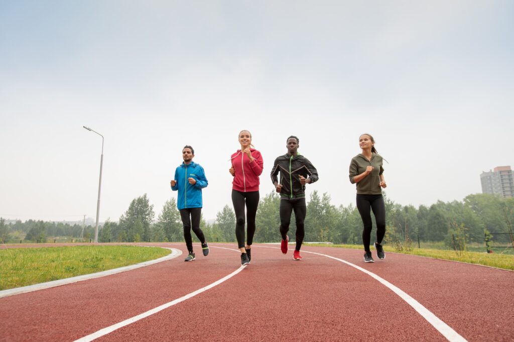 A mixed group of runners training together on an outdoor track